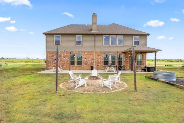 back of house featuring a fire pit, a patio, and a yard