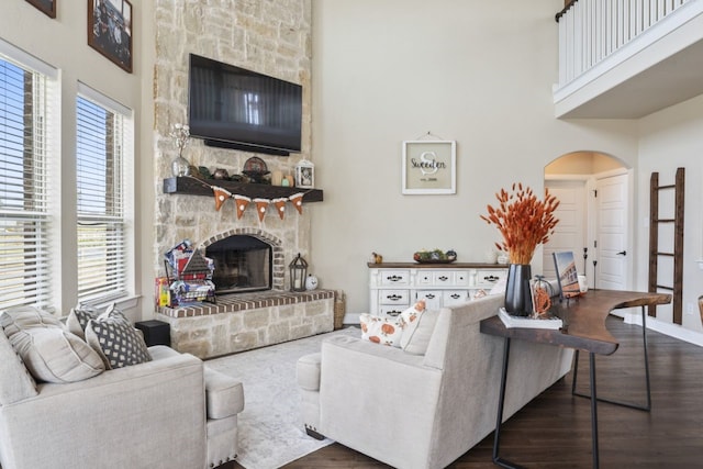 living room featuring a fireplace, dark hardwood / wood-style floors, and a high ceiling