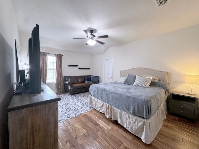 bedroom featuring hardwood / wood-style floors, a textured ceiling, and ceiling fan