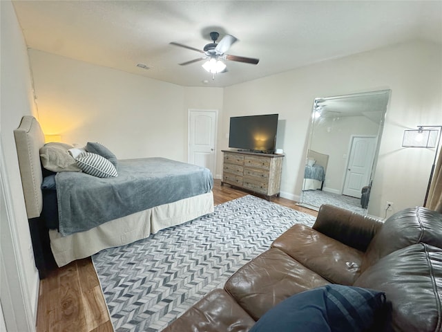 bedroom with ceiling fan, lofted ceiling, and hardwood / wood-style flooring