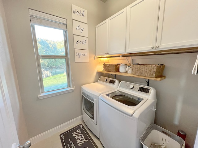 washroom with washing machine and clothes dryer and cabinets