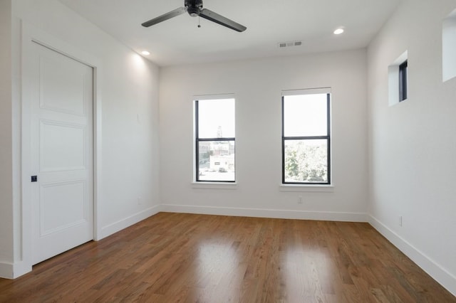 empty room with dark wood-type flooring and ceiling fan