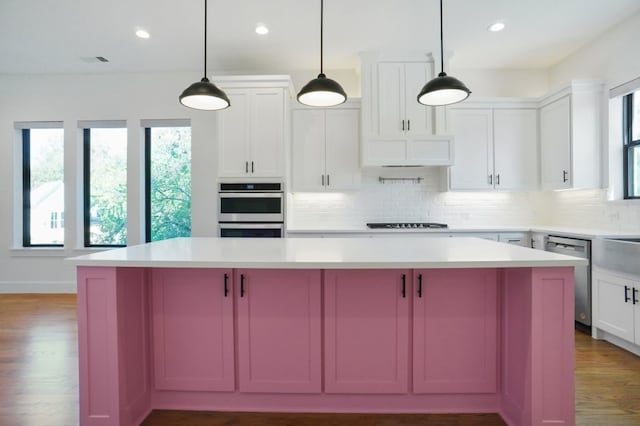 kitchen featuring stainless steel appliances, a kitchen island, and hardwood / wood-style floors