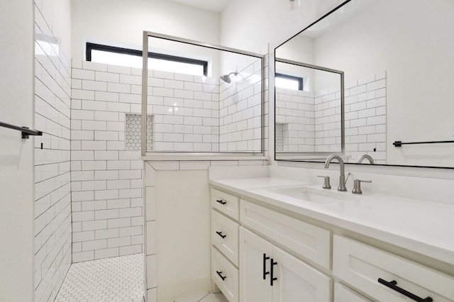 bathroom featuring plenty of natural light, vanity, and a tile shower