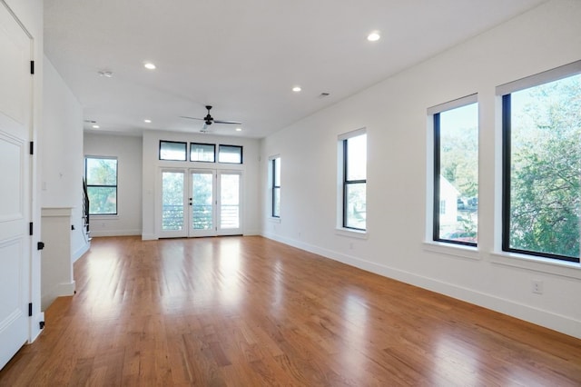 unfurnished living room with ceiling fan, light hardwood / wood-style flooring, and french doors