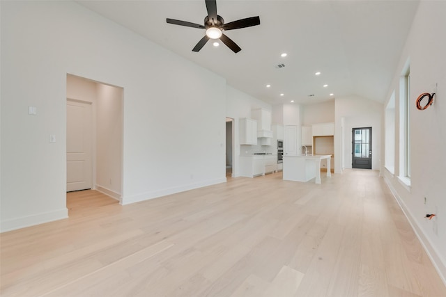 unfurnished living room with light wood finished floors, baseboards, ceiling fan, high vaulted ceiling, and recessed lighting