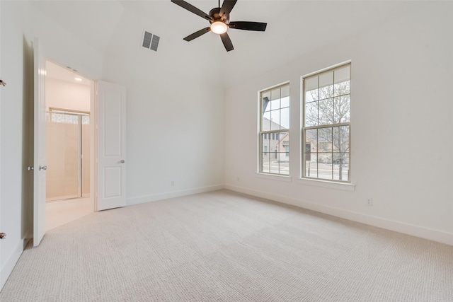 empty room with light carpet, a ceiling fan, visible vents, and baseboards