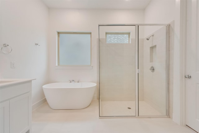 full bathroom with a shower stall, a freestanding bath, and vanity