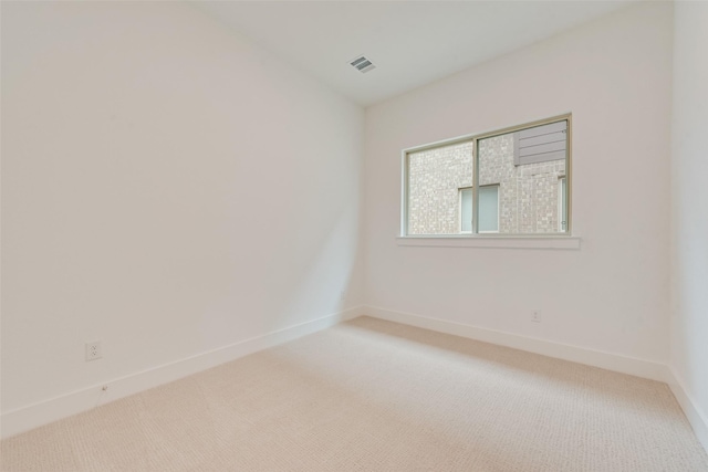 spare room featuring carpet flooring, visible vents, and baseboards