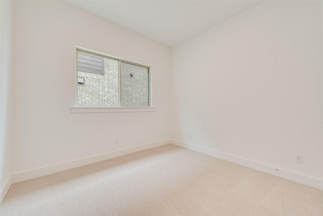 carpeted empty room with baseboards