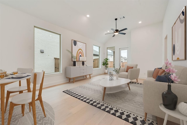 living area with baseboards, visible vents, lofted ceiling, light wood-style floors, and recessed lighting