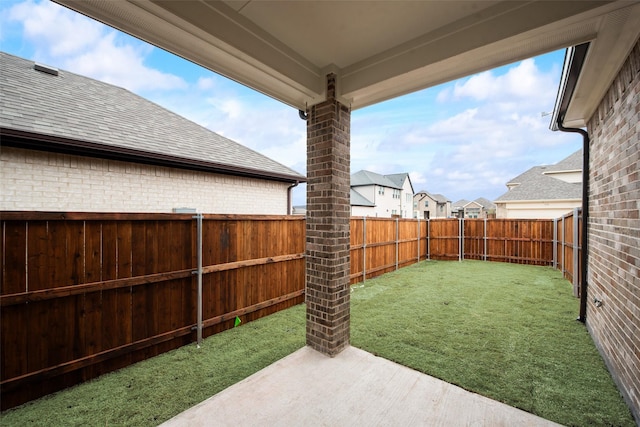 view of yard featuring a fenced backyard, a residential view, and a patio