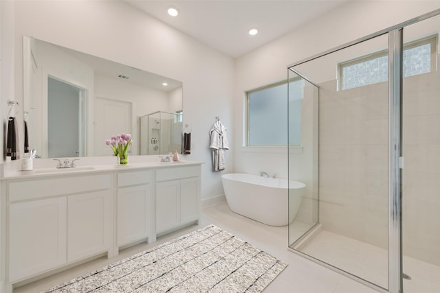 full bath with a stall shower, a freestanding tub, a sink, and double vanity