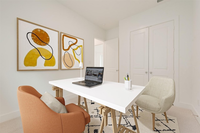 office space with baseboards and light colored carpet