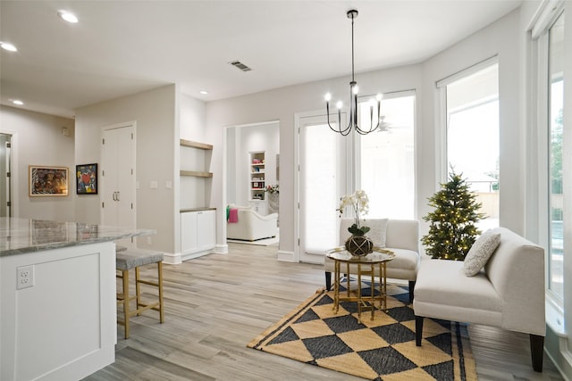 dining space featuring light hardwood / wood-style flooring and an inviting chandelier