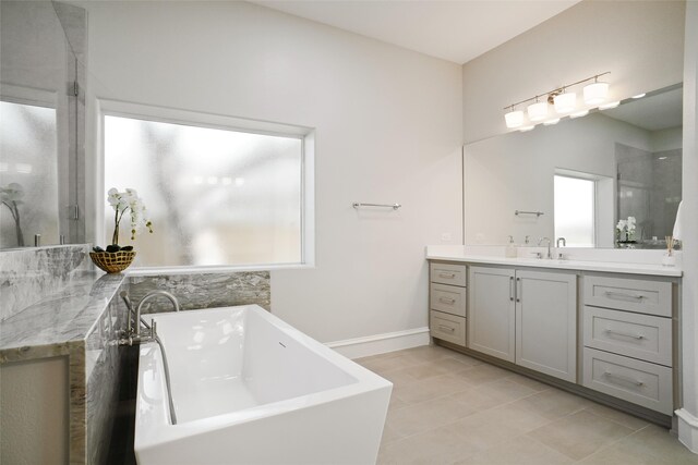 bathroom featuring shower with separate bathtub, vanity, and tile patterned floors