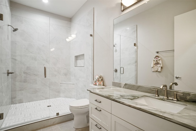 bathroom featuring walk in shower, vanity, toilet, and tile patterned flooring