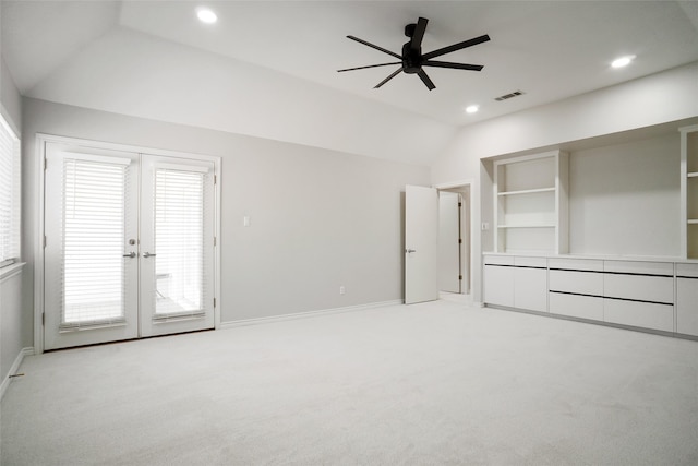 unfurnished bedroom featuring lofted ceiling, french doors, light colored carpet, and ceiling fan