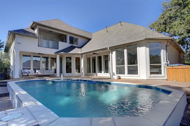 rear view of property with ceiling fan, a balcony, a patio, and an outdoor hangout area