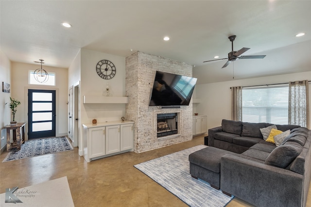 living room with a fireplace and ceiling fan