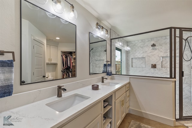 bathroom with a tile shower and vanity