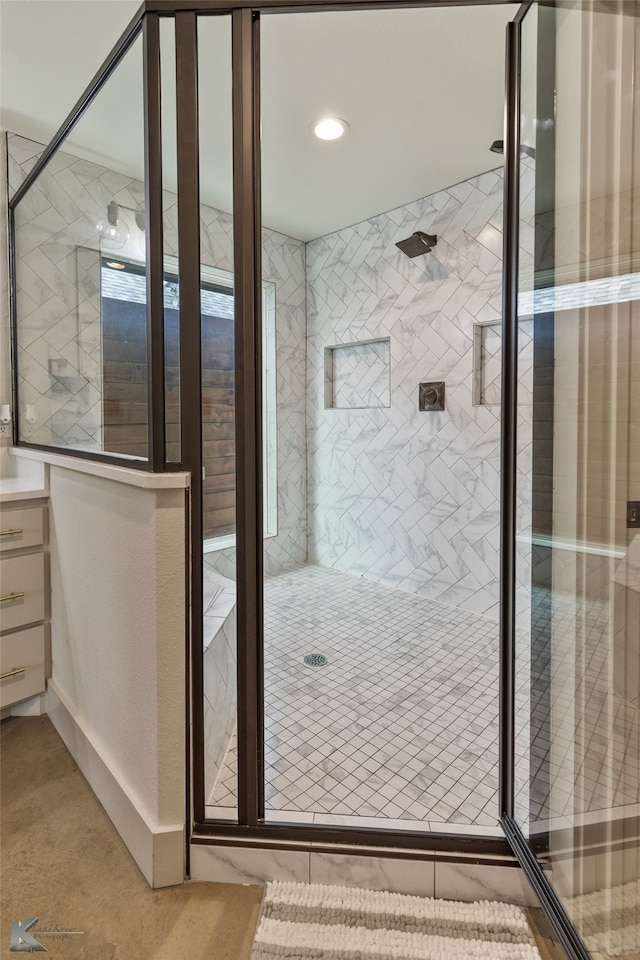 bathroom featuring a tile shower and vanity