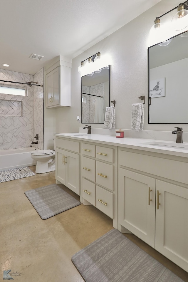 full bathroom featuring vanity, tiled shower / bath, and toilet