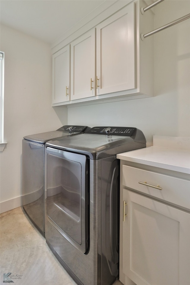 laundry room with independent washer and dryer and cabinets