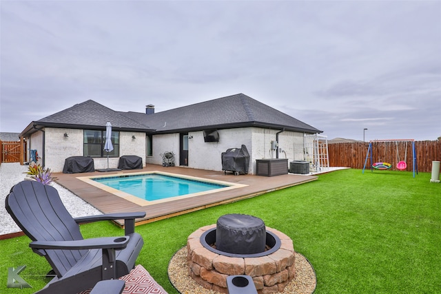 view of pool with a yard, a fire pit, a grill, and central air condition unit