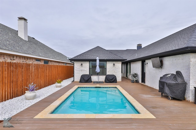 view of pool featuring area for grilling and a deck