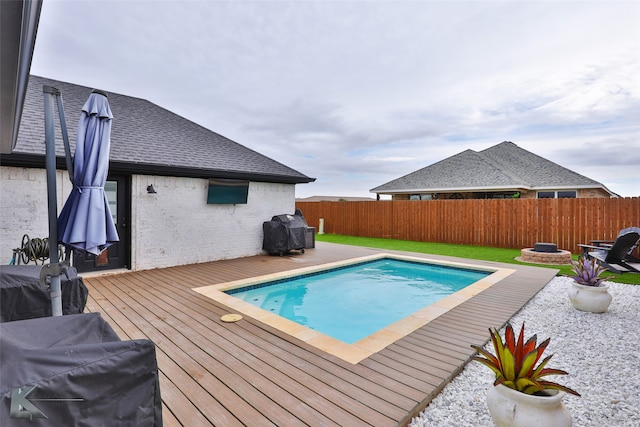 view of swimming pool with a wooden deck and grilling area