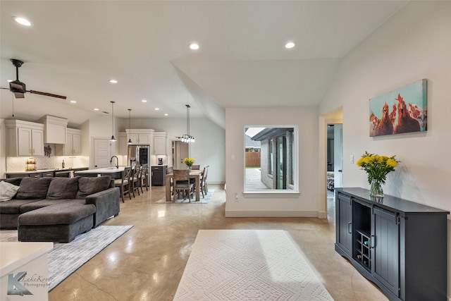 living room featuring sink, lofted ceiling, and ceiling fan