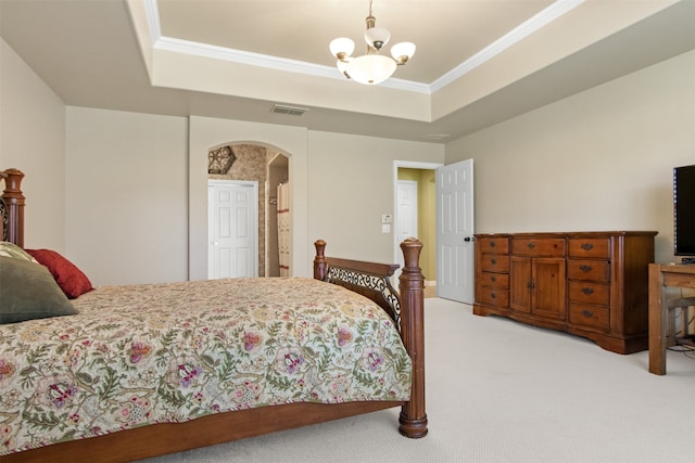 carpeted bedroom with crown molding, a tray ceiling, and an inviting chandelier