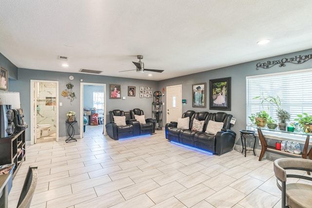 living room with a textured ceiling and ceiling fan