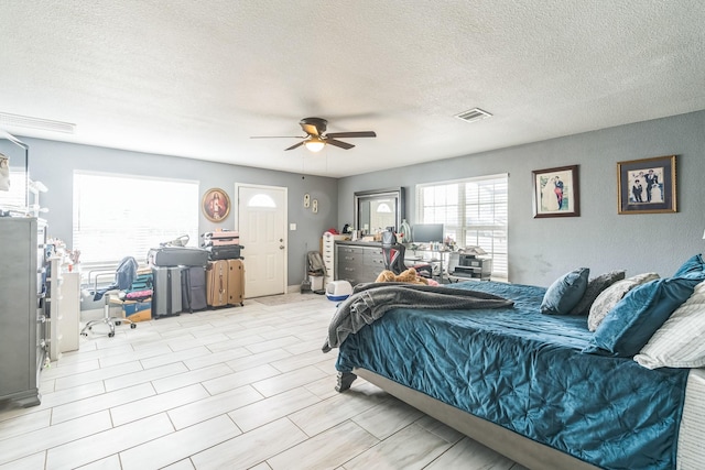 bedroom featuring ceiling fan and a textured ceiling