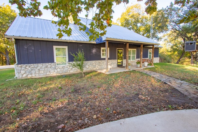 view of front of home featuring a front lawn and a patio