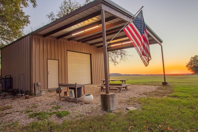 outdoor structure at dusk featuring a lawn