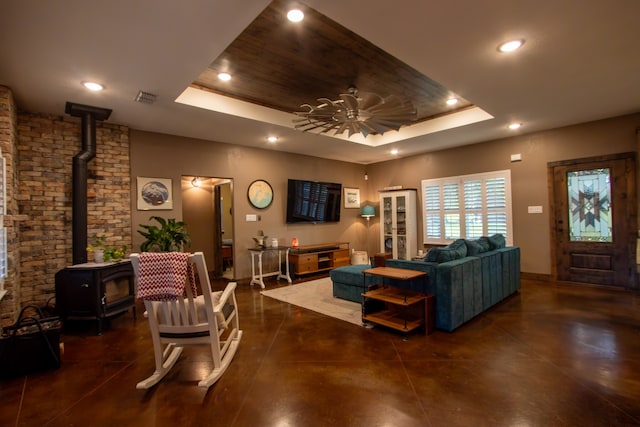 living room featuring ceiling fan and a raised ceiling