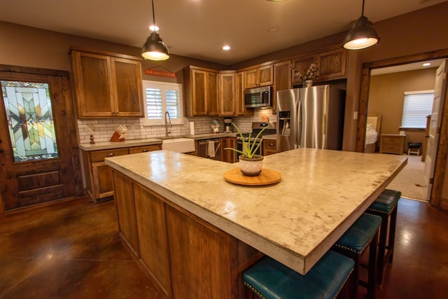 kitchen featuring pendant lighting, sink, a center island, and stainless steel appliances