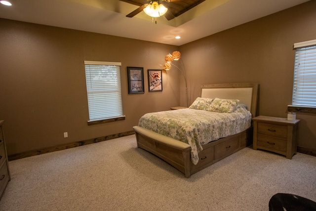 bedroom featuring a tray ceiling, ceiling fan, and light colored carpet