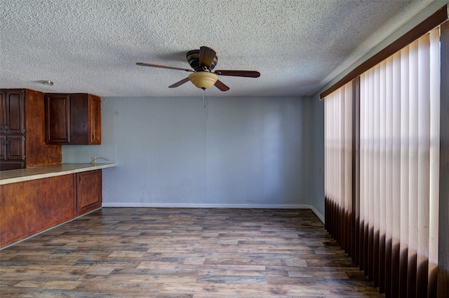 kitchen with dark wood-type flooring, a textured ceiling, and ceiling fan