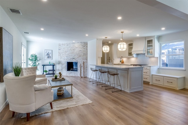 living room featuring sink, a fireplace, and light wood-type flooring