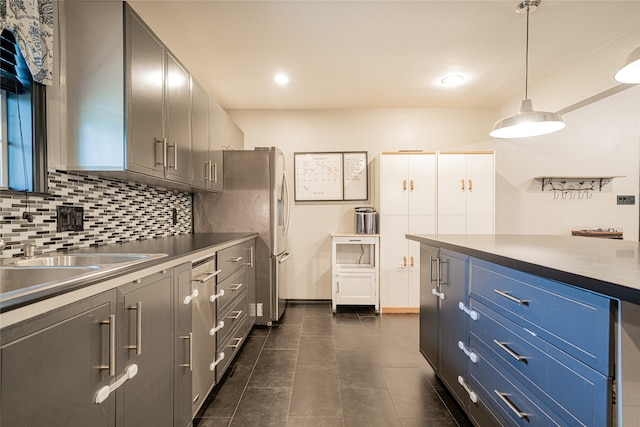 kitchen featuring stainless steel fridge, dark tile patterned floors, pendant lighting, sink, and decorative backsplash