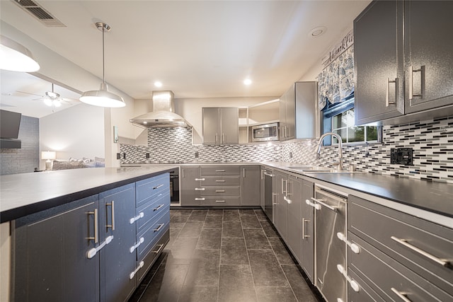 kitchen with stainless steel appliances, sink, tasteful backsplash, wall chimney exhaust hood, and gray cabinetry