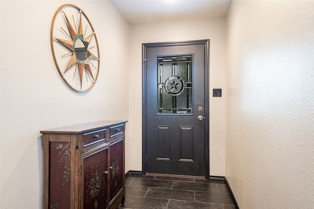 entryway with dark tile patterned floors