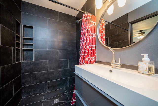 bathroom featuring vanity, curtained shower, a textured ceiling, and ceiling fan