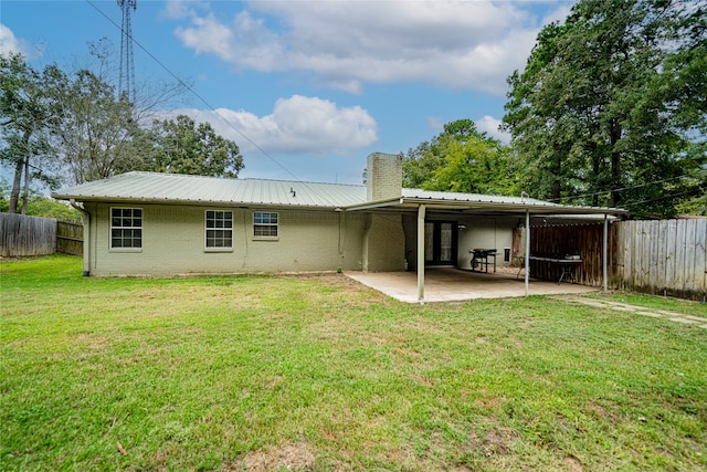 back of house featuring a lawn and a patio area