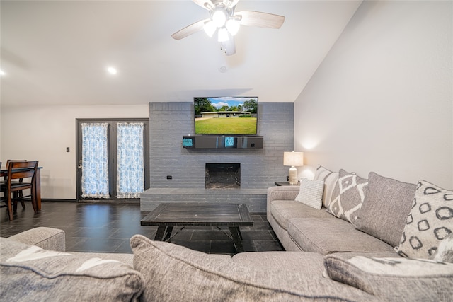 tiled living room with vaulted ceiling, ceiling fan, and a fireplace