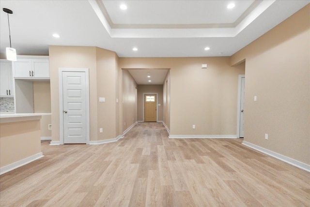 interior space featuring light hardwood / wood-style floors and a tray ceiling