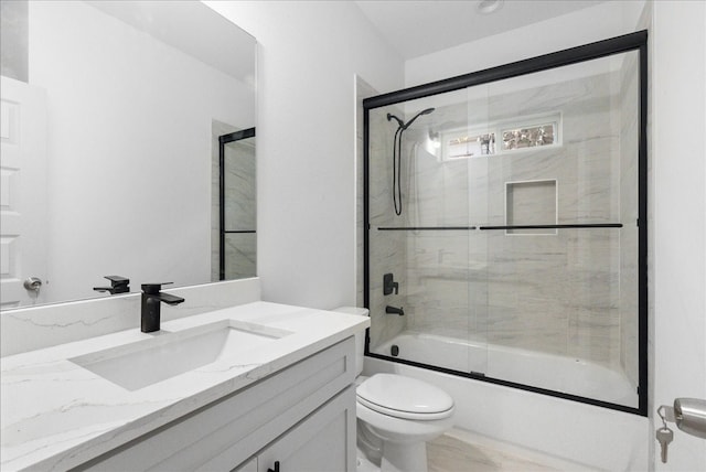 full bathroom featuring toilet, combined bath / shower with glass door, and vanity